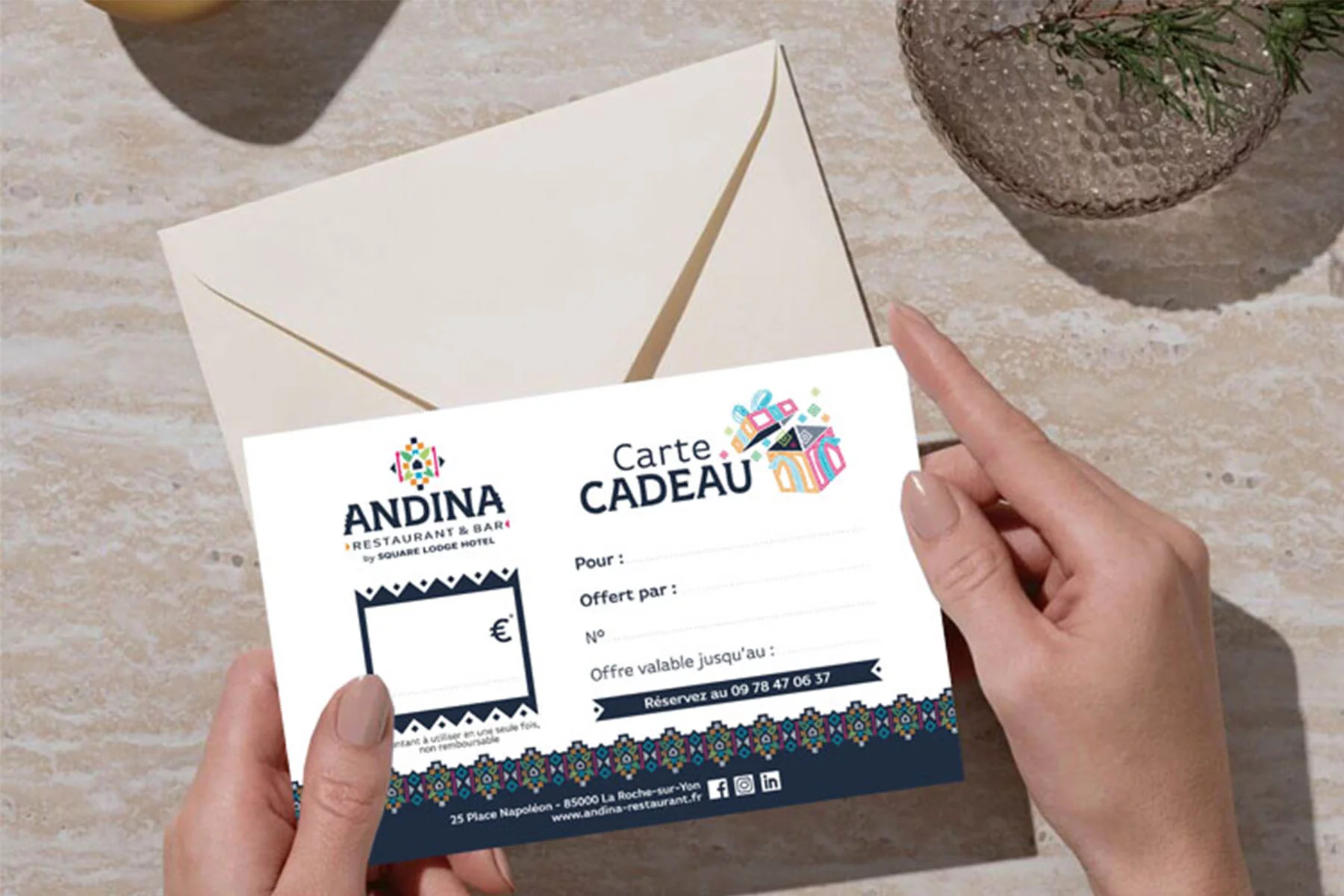 Carte cadeau Andina tenue par les mains d'une femme, idéale pour offrir une expérience culinaire unique au Restaurant Andina.